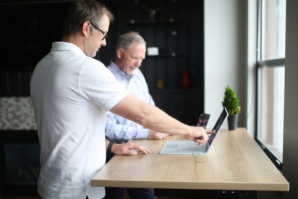 Helping a client with his laptop at a desk
