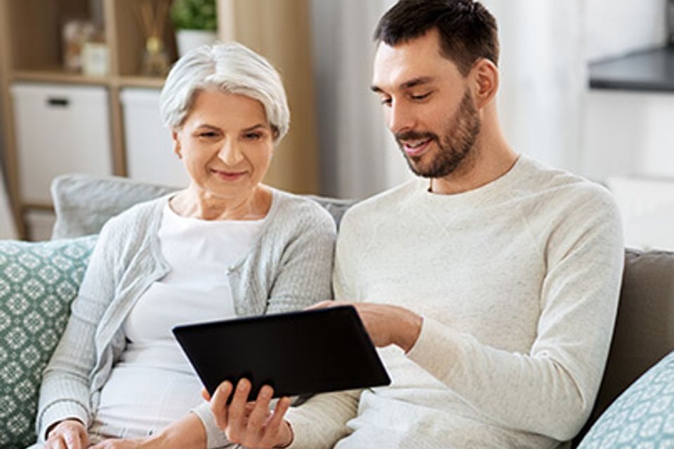 Showing an older woman features on her tablet